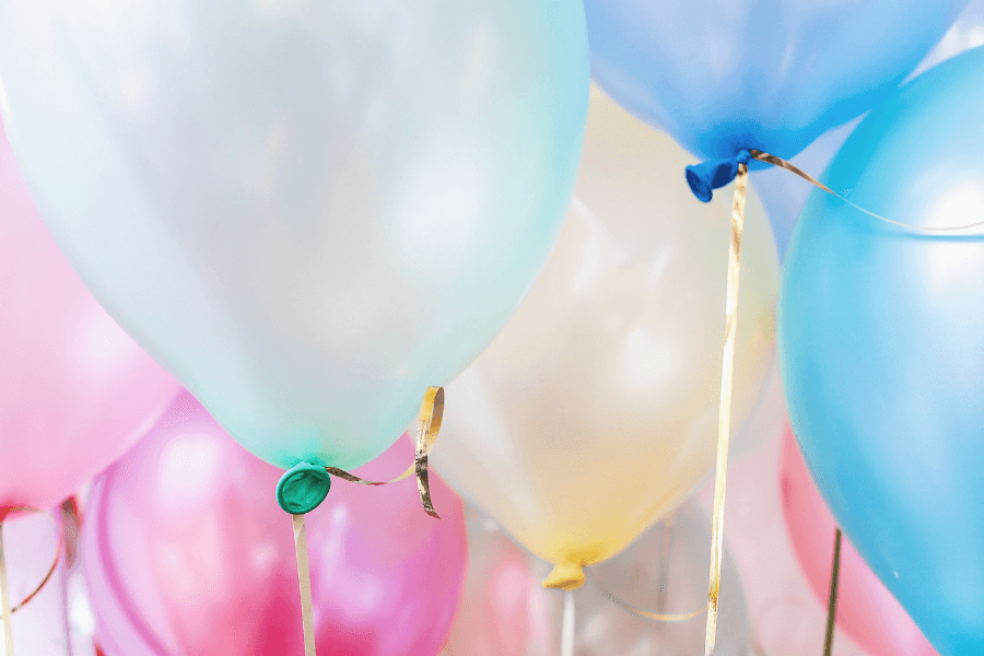 A cluster of colorful balloons in pastel shades.